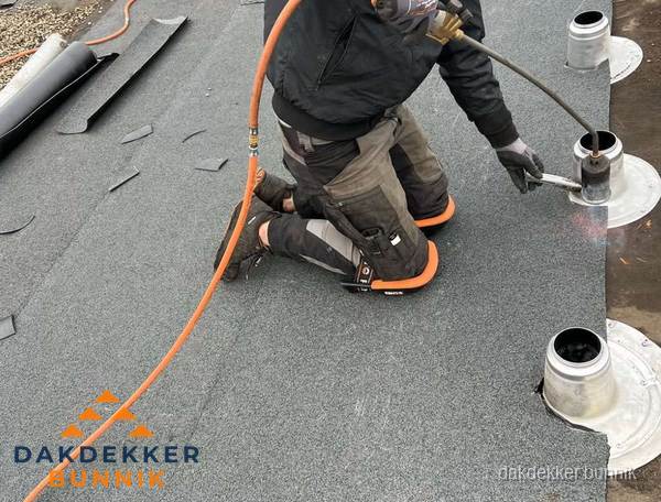 Dakdekker repareert bitumen dakleer bij dakdoorvoer in Bunnik Dakdekker repareert bitumen dakleer bij dakdoorvoer in Bunnik
