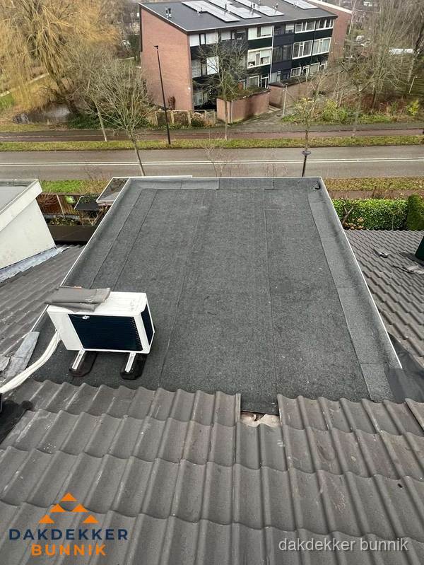 Plat dak inspectie met bitumen bedekking naast schuin pannendak in Bunnik Plat dak inspectie met bitumen bedekking naast schuin pannendak in Bunnik